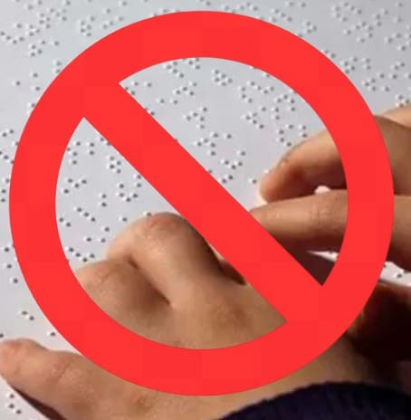 A imagem mostra duas mãos a tocar numa folha com braille. Por cima, há um grande símbolo de proibição em vermelho (um círculo com uma linha diagonal), a indicar que algo relacionado com o braille está “proibido” ou “não permitido”.